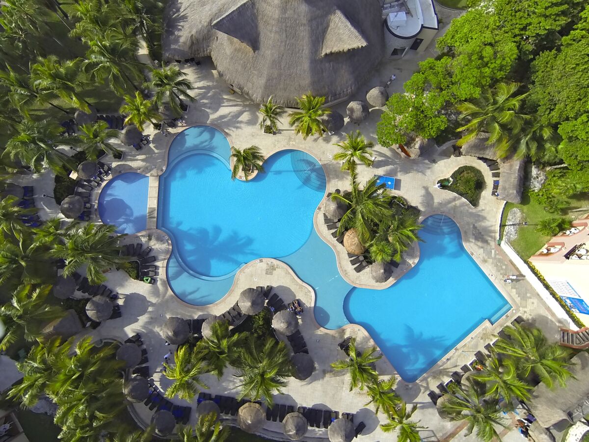 Vista aérea de las albercas entre jardines en Sandos Playacar